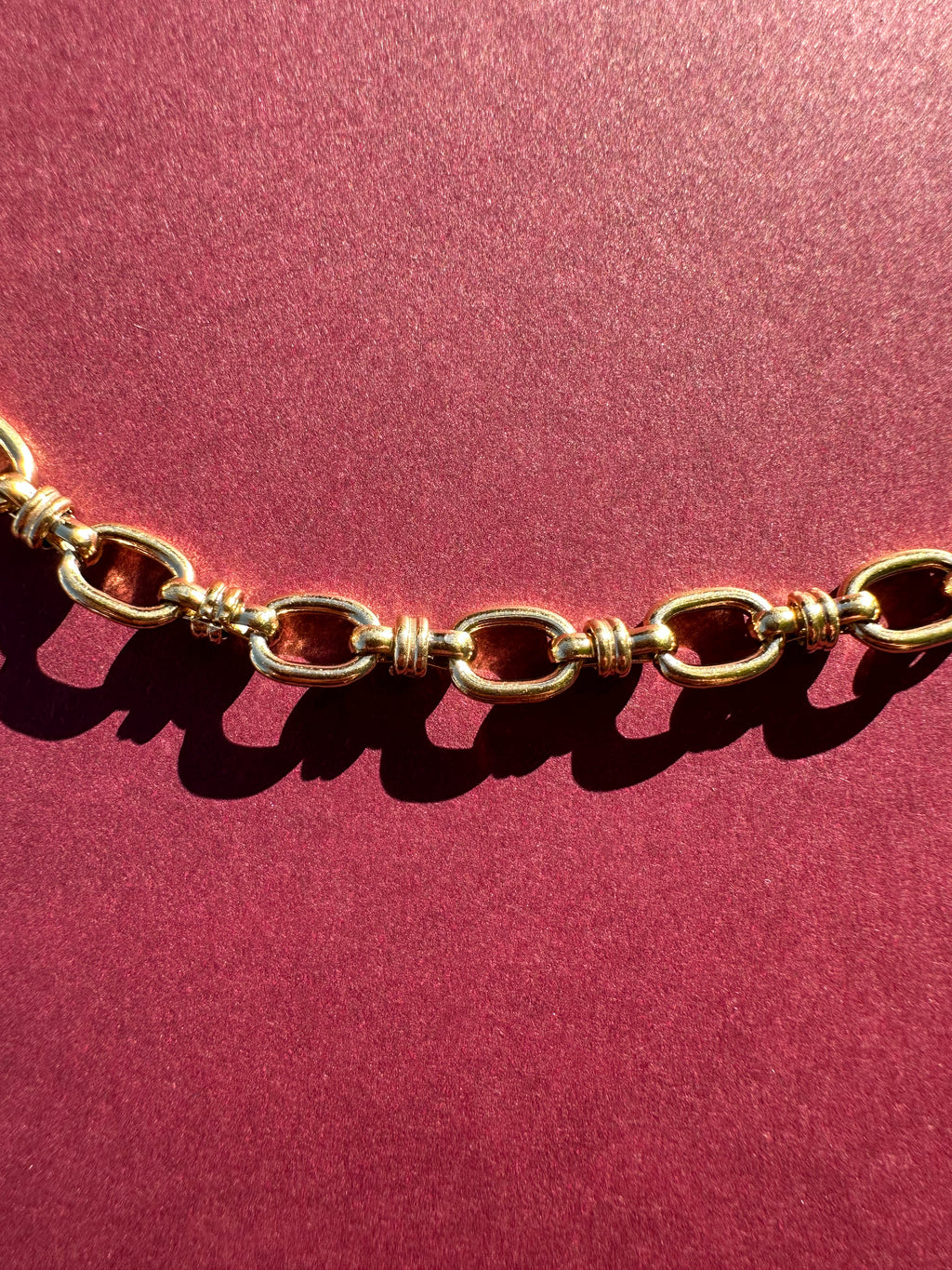 Close up of Cable link necklace On maroon background 