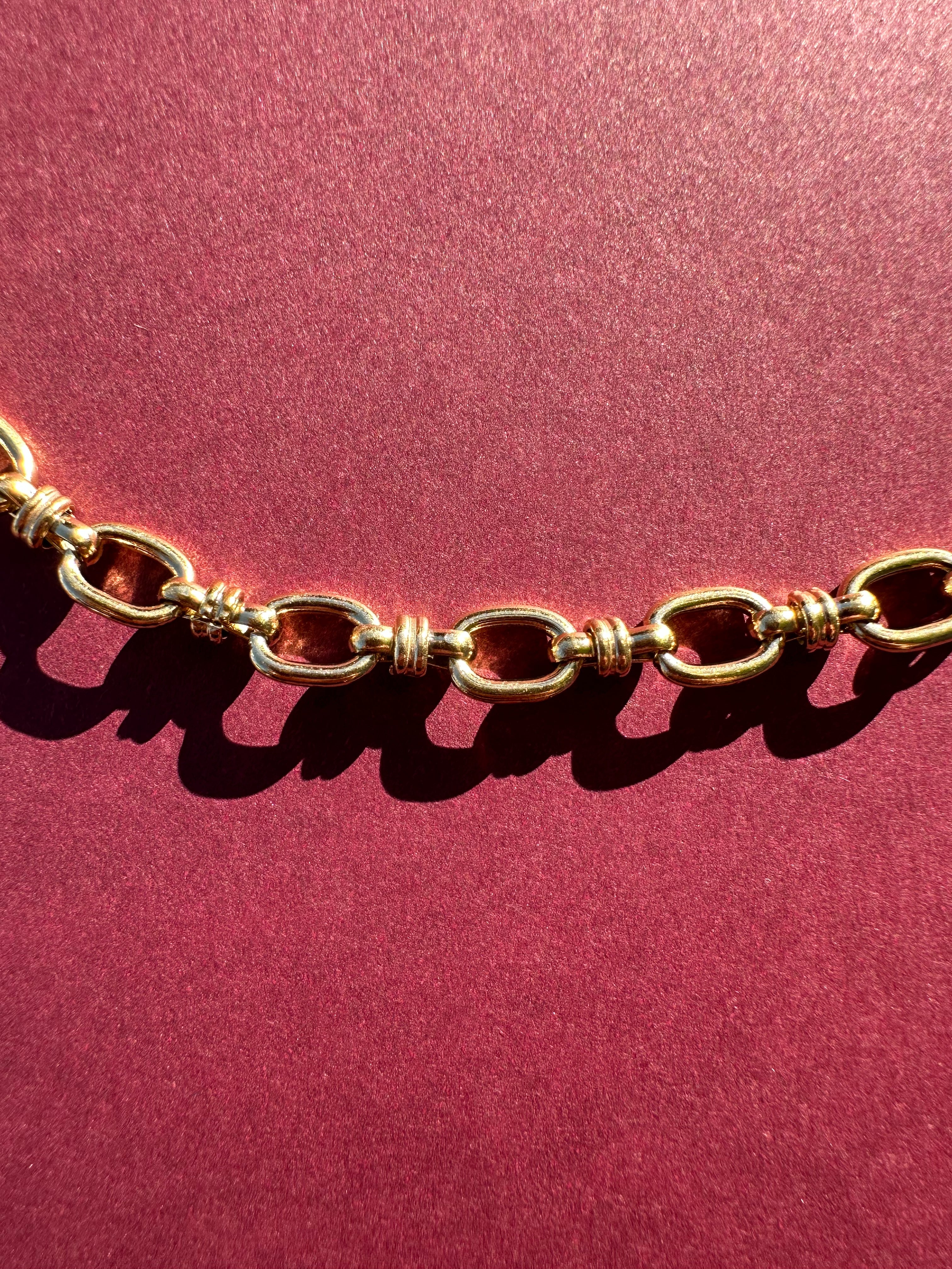 Close up of Cable link necklace On maroon background 
