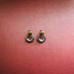 Two tone earrings on maroon background 