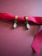 Marquise Huggie Hoops On maroon background 