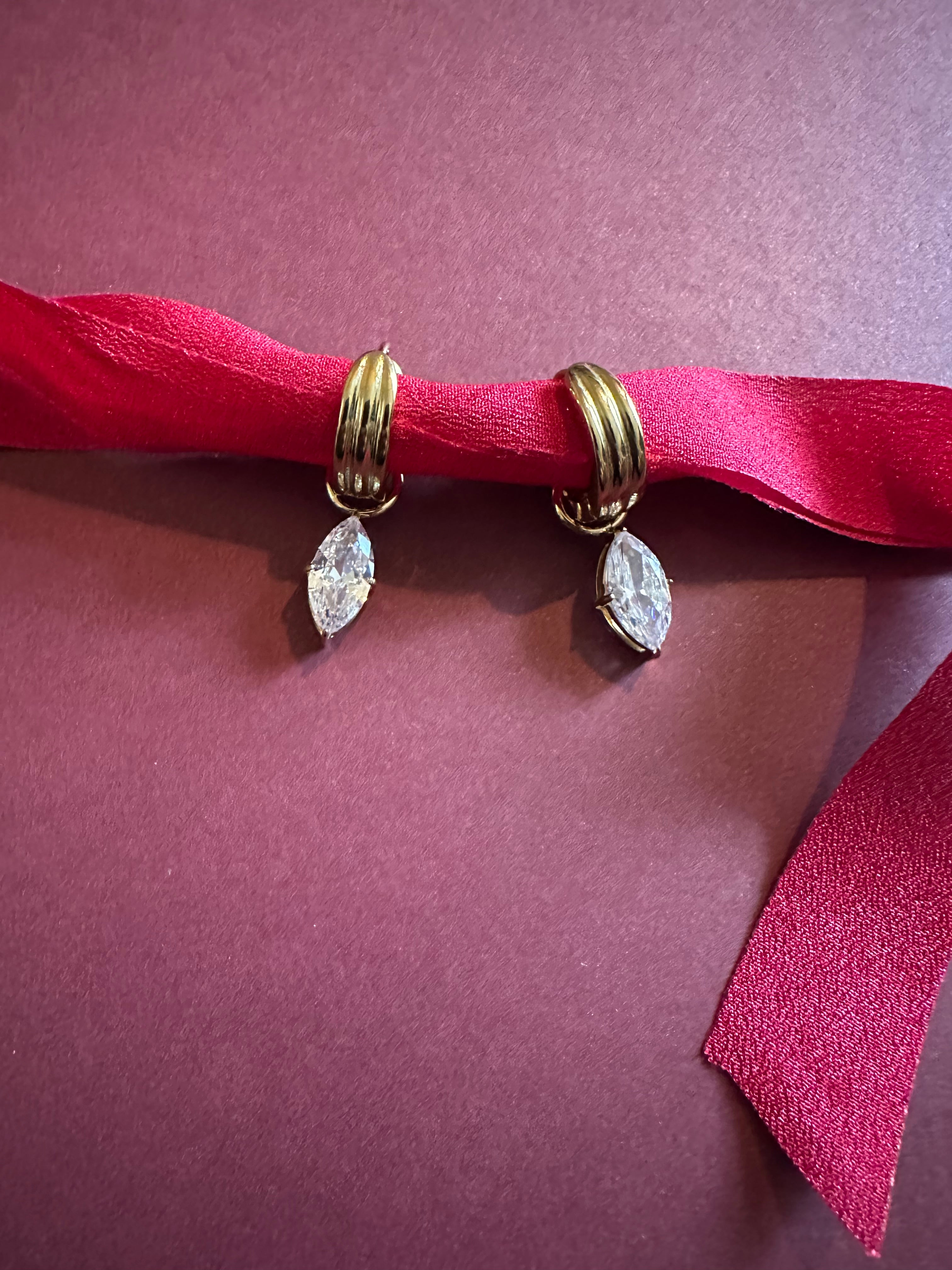 Marquise Huggie Hoops On maroon background 