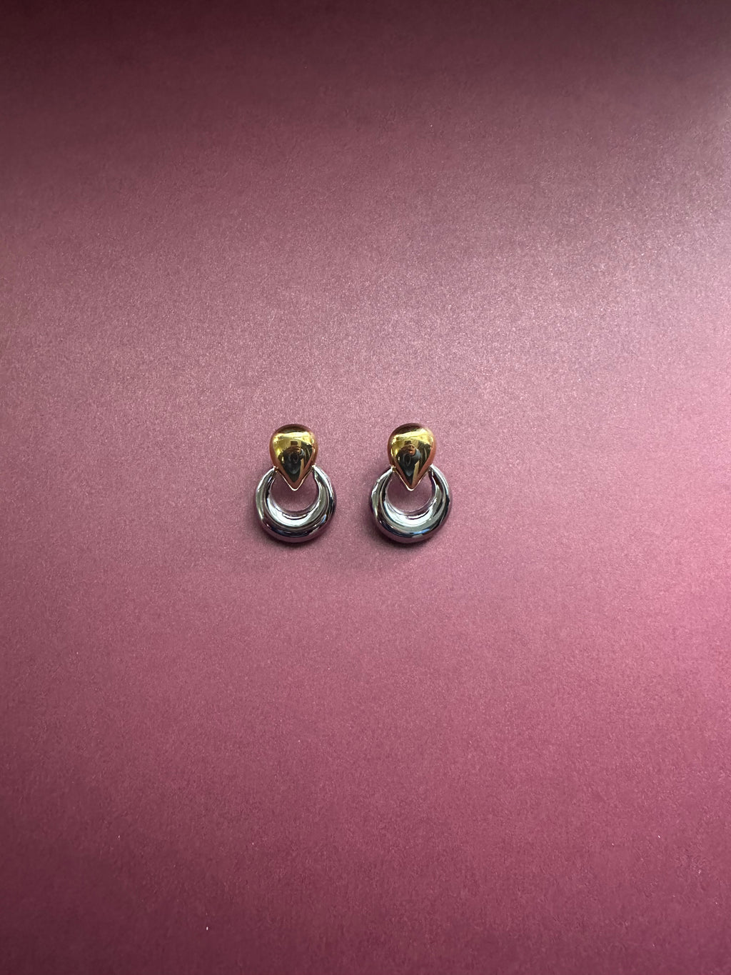 Two tone earrings with marrón background 