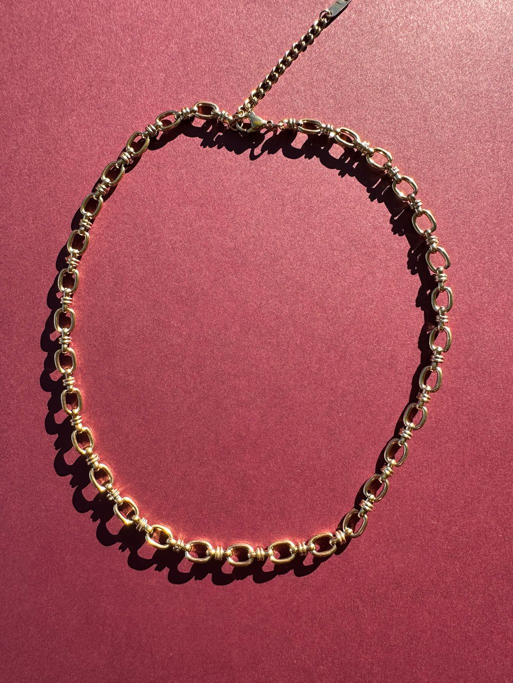 Cable link necklace On maroon background 