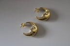 Gold crescent moon-shaped earrings on a light gray background