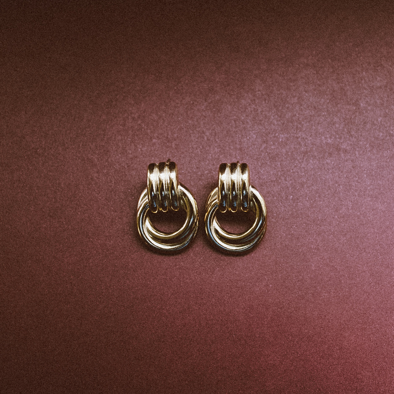 Bold Statement Stud Earrings Gold with maroon background